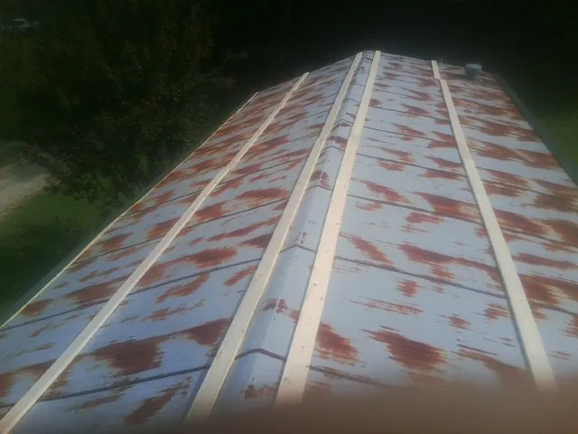 Rusted metal roof panels with new wood purlins before replacement — Storm Damage Roof Repair in Freeville by Roofing Brothers