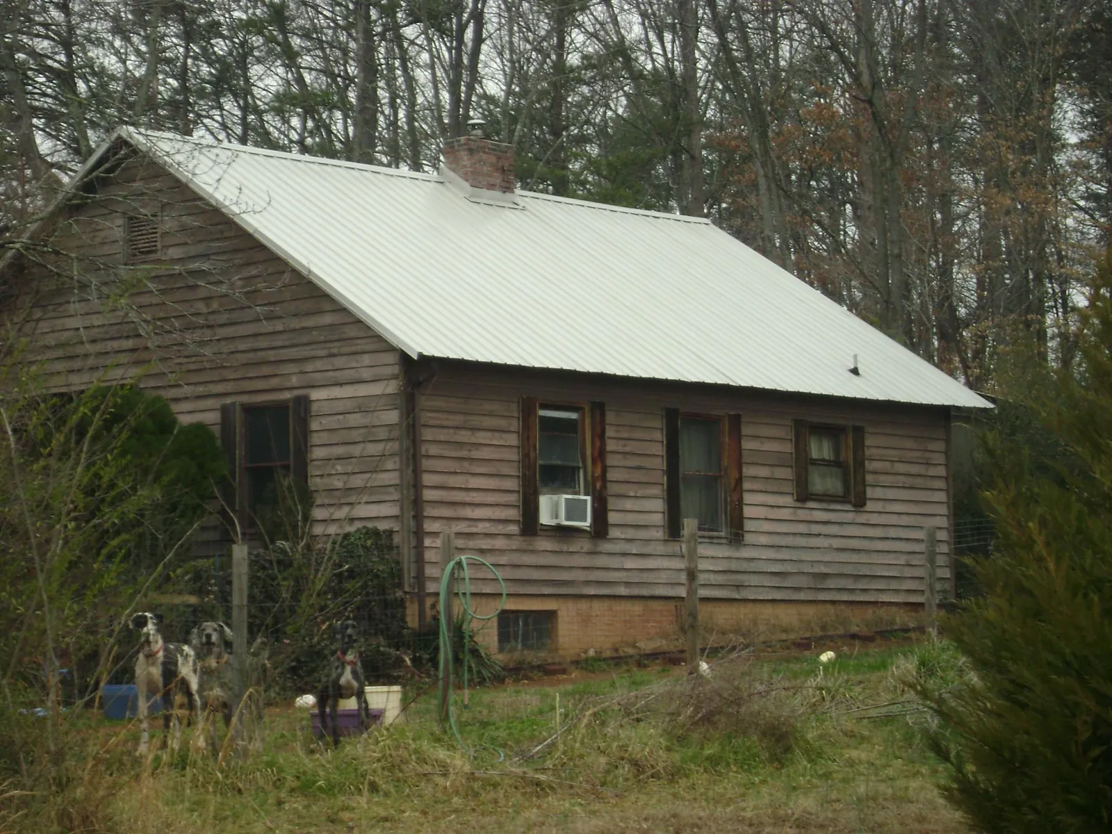 White metal roof on an old wood sided farmhouse, from a Metal Roof Installation job in Freeville
